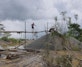 A miner walking from one sand mount to another in the mining concession.