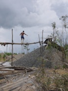 A miner walking from one sand mount to another in the mining concession.