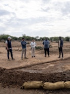 Wyss Academy and local partners during a field check at a semicircular bund site, where community-led monitoring supports comparisons between restored plots and nearby untreated rangeland.