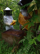 Beekeepers learn how to fit a queen excluder—used to keep the queen out of honey frames—during a practical training session.