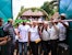 A group cuts a pink ribbon at the entrance to the Mirohy Center in Masindrano, framed by open turquoise gates and a leafy arch, while other participants look on.