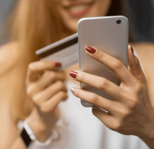 Kobieta z telefonem oraz kartą płatniczą