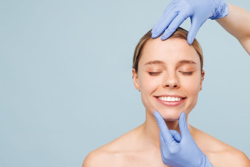A woman with a docs hands on her face