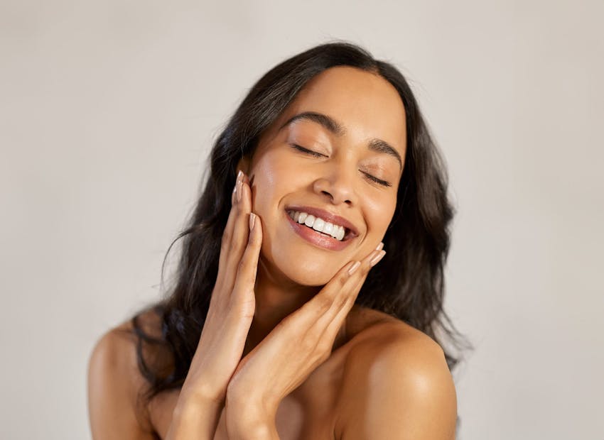 woman with her hands touching her face