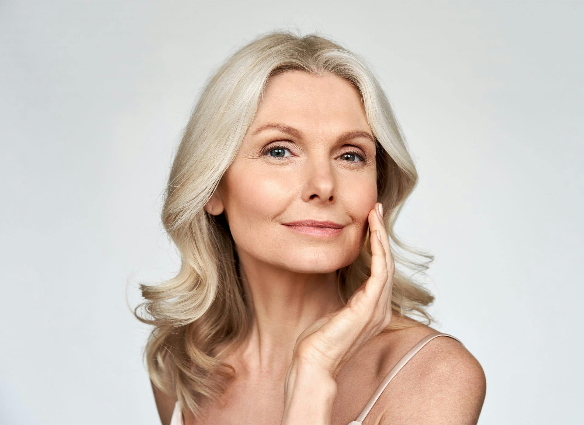 blonde woman touching her cheek