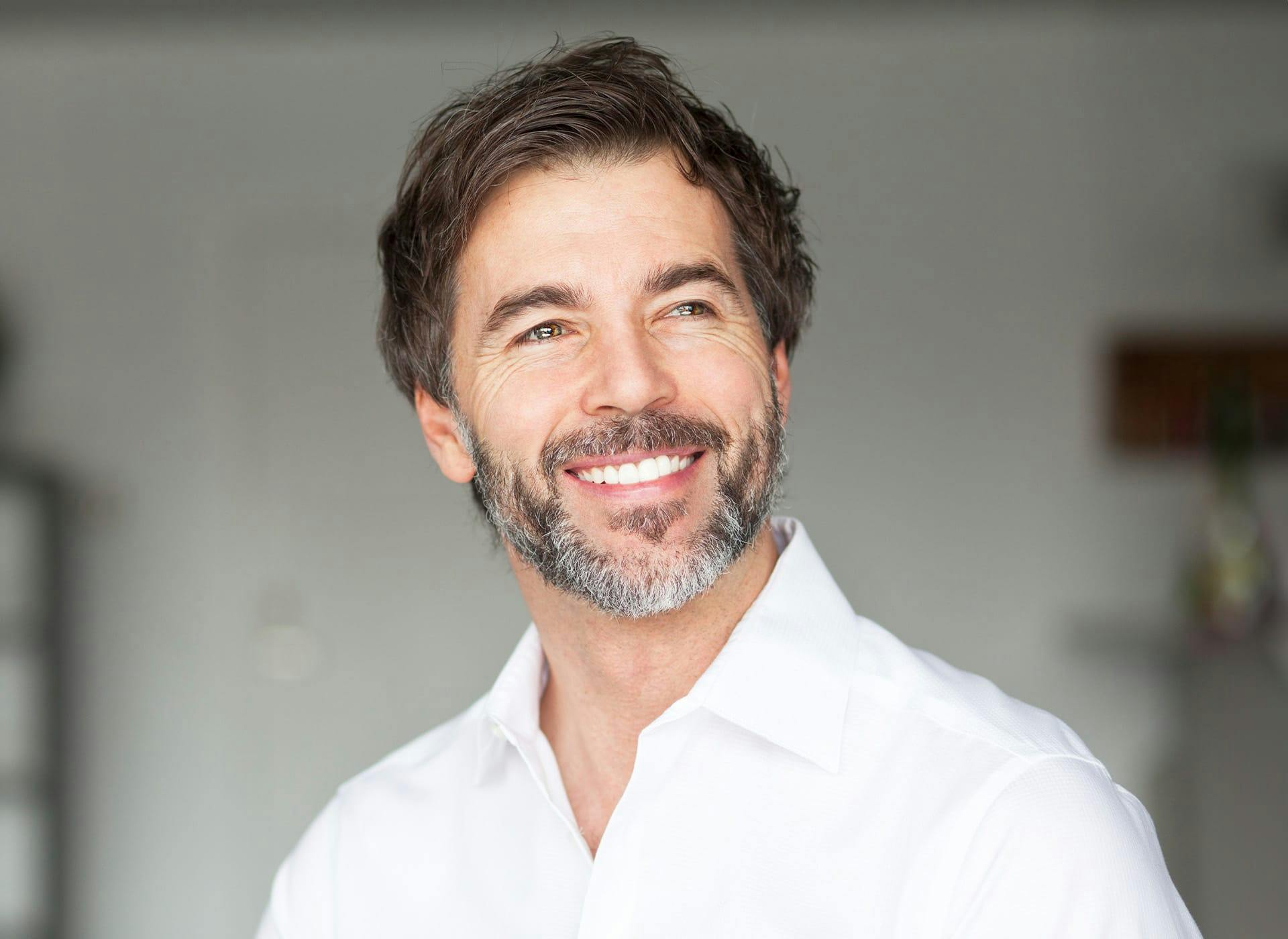 man in white polo smiling