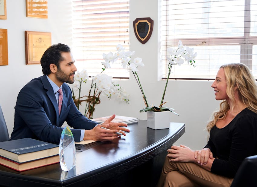 Dr. Alemi at desk with client across from him