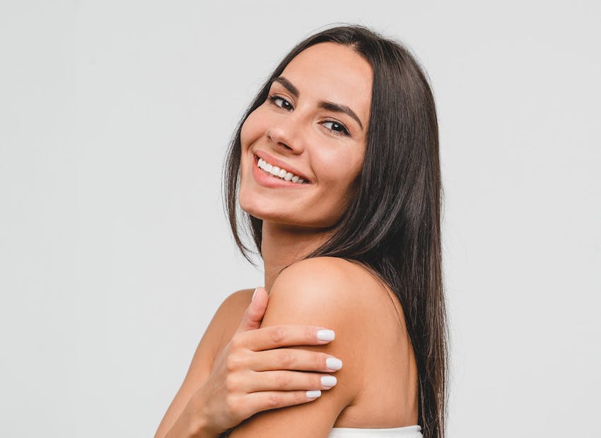 woman putting her hand around her shoulder