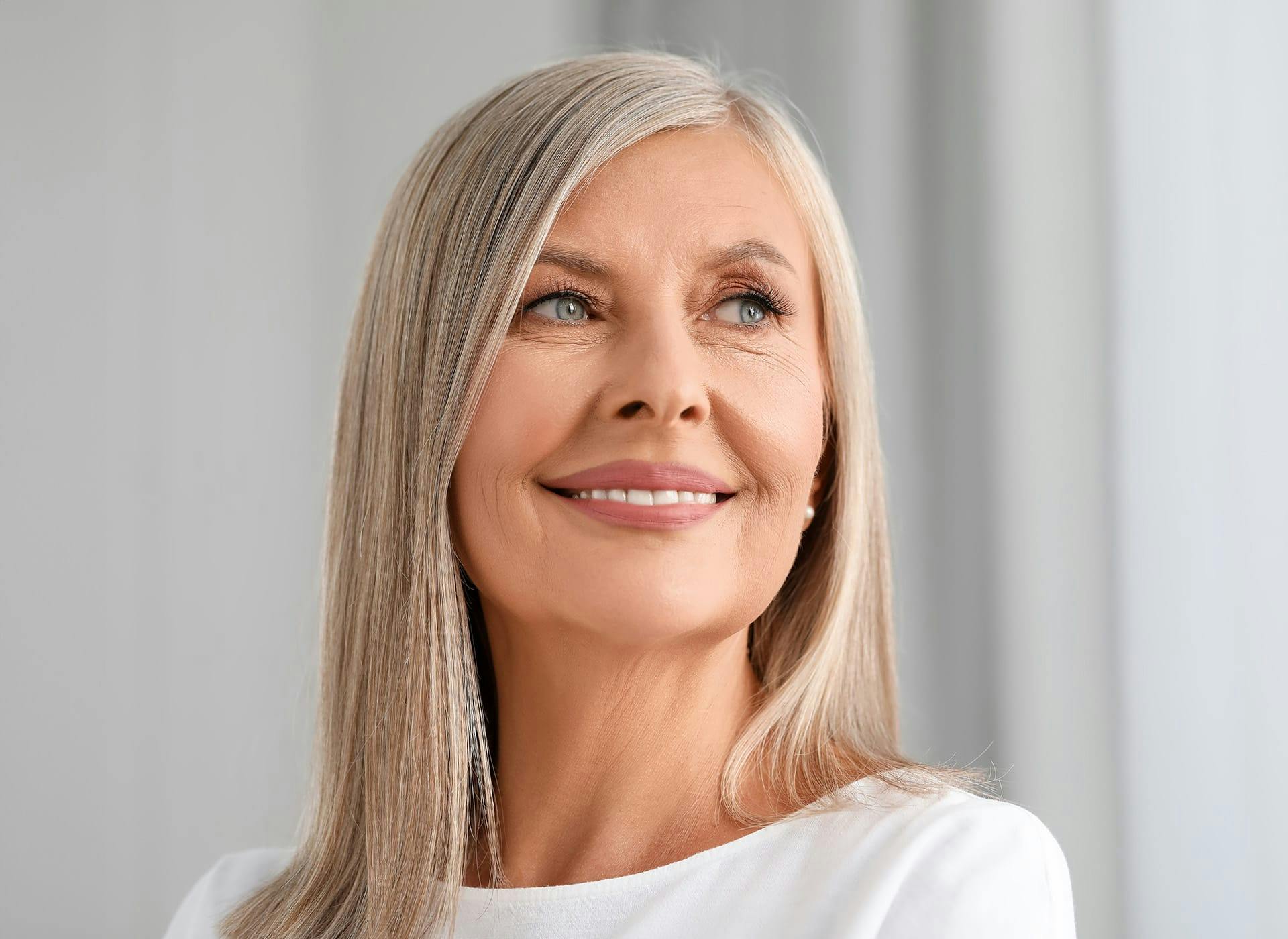 woman with gray hair smiling looking to the right