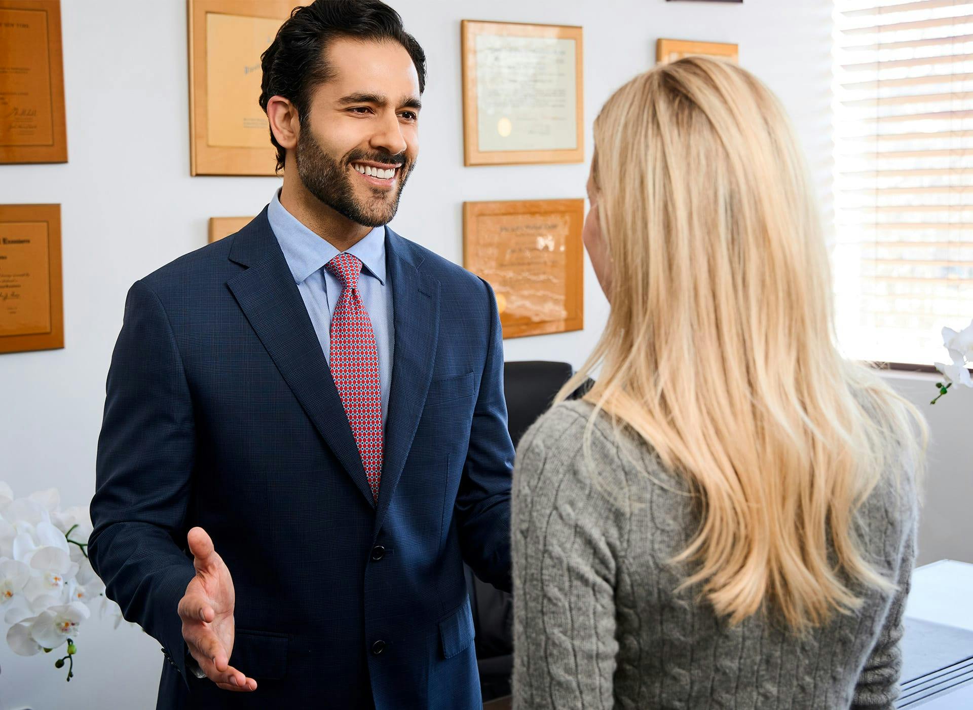Dr. Alemi in suit speaking to client