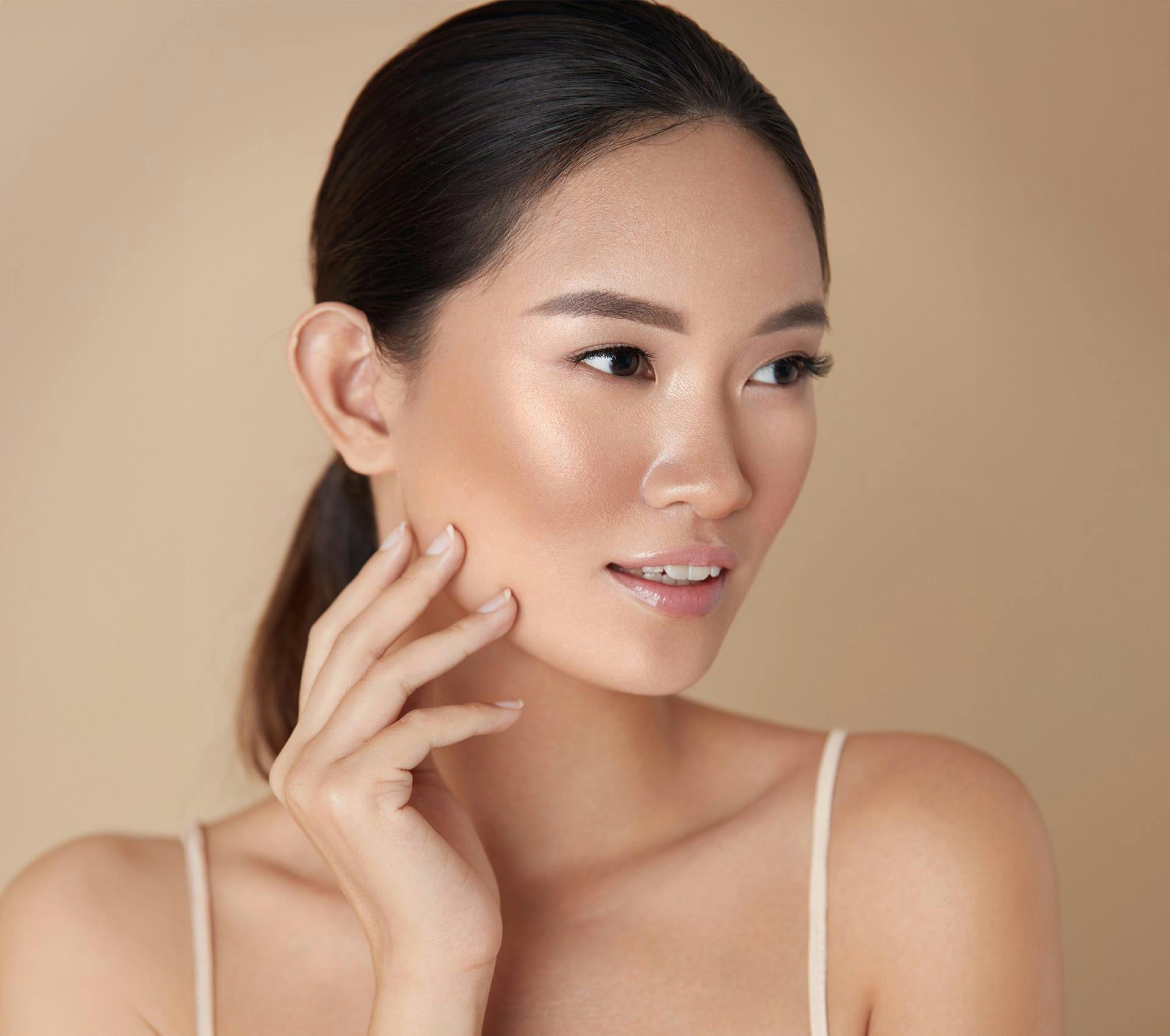 asian woman looking to the right with hand touching her jaw