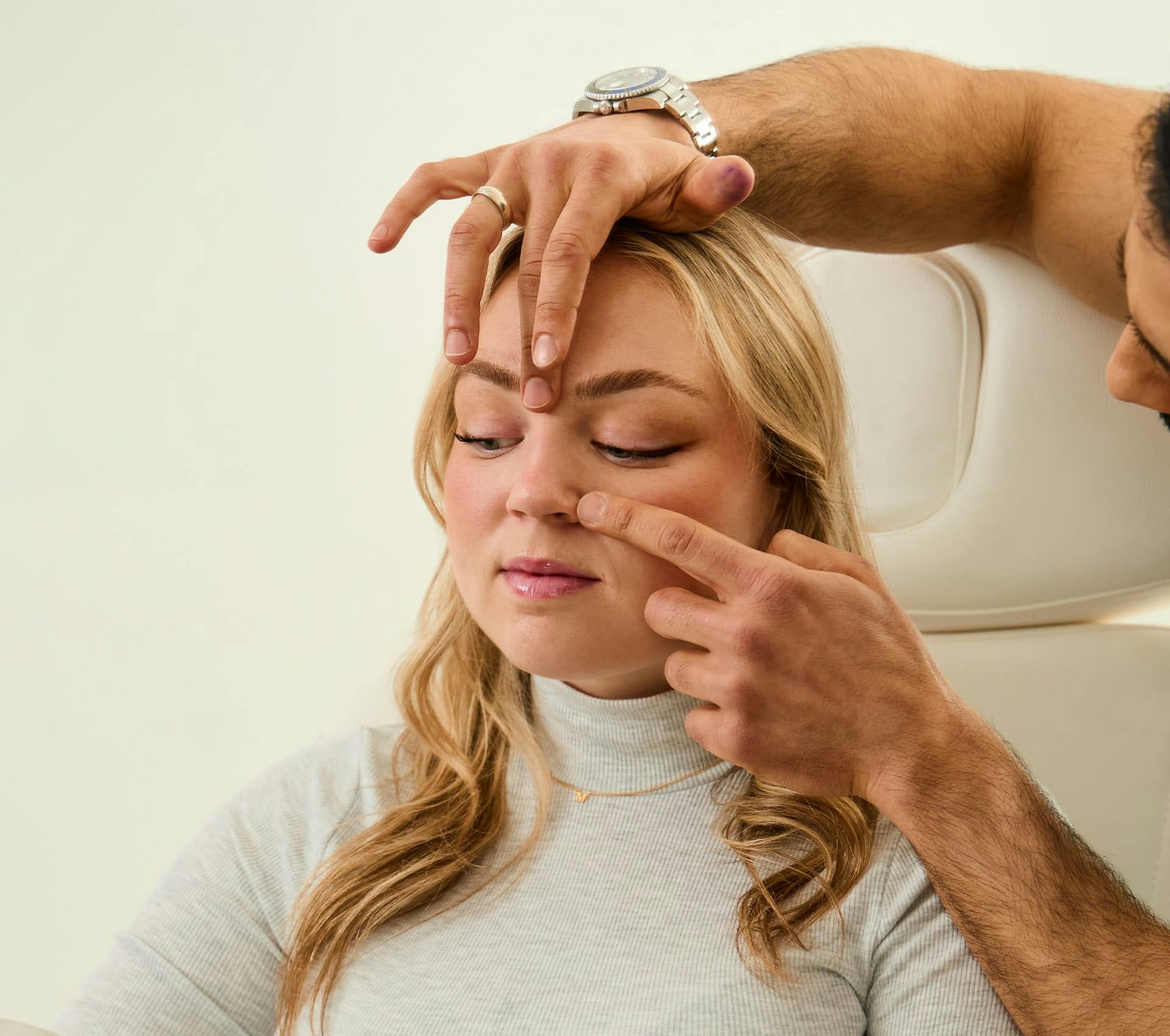client getting her nose checked by Dr. Alemi