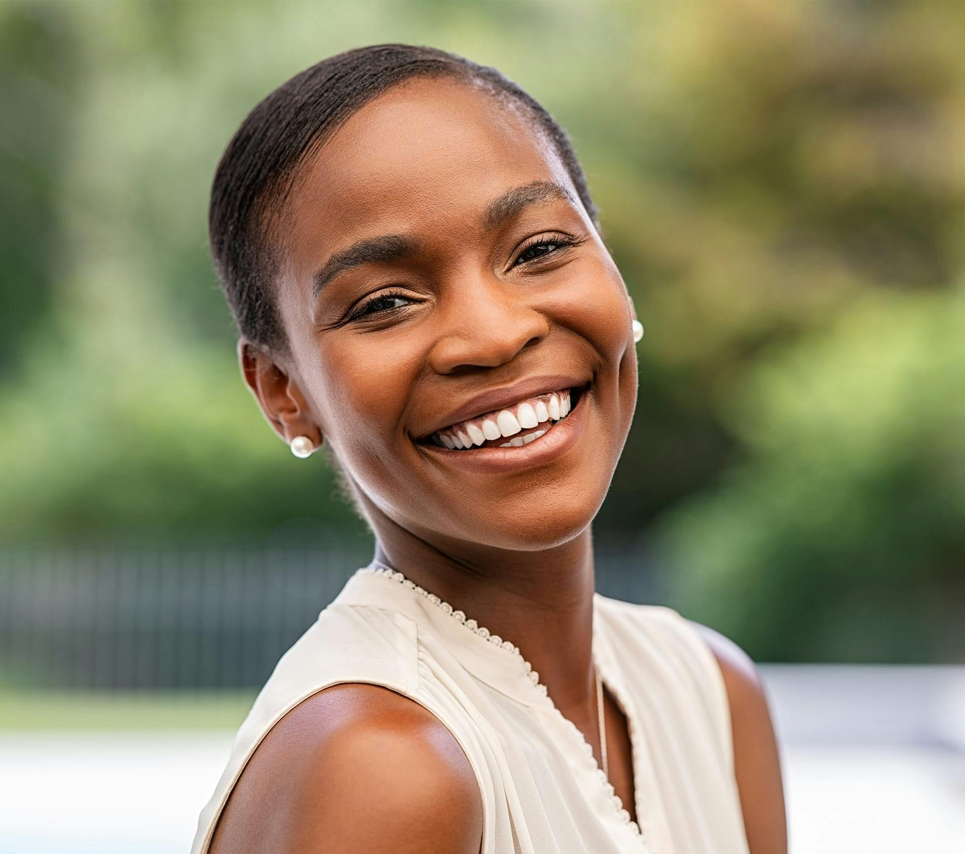 woman with short hair with white top smiling