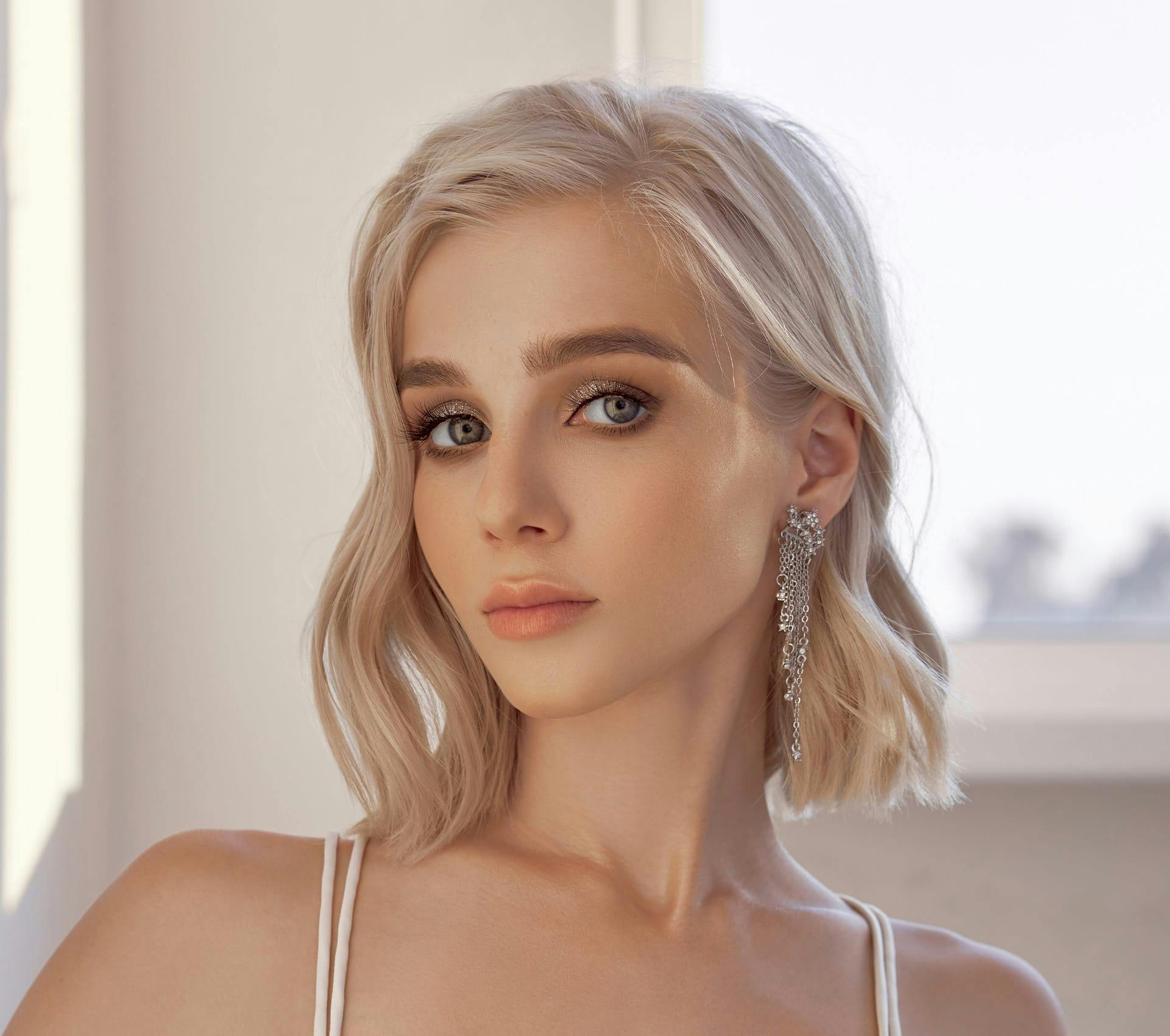 woman with short blonde hair with dangling earring