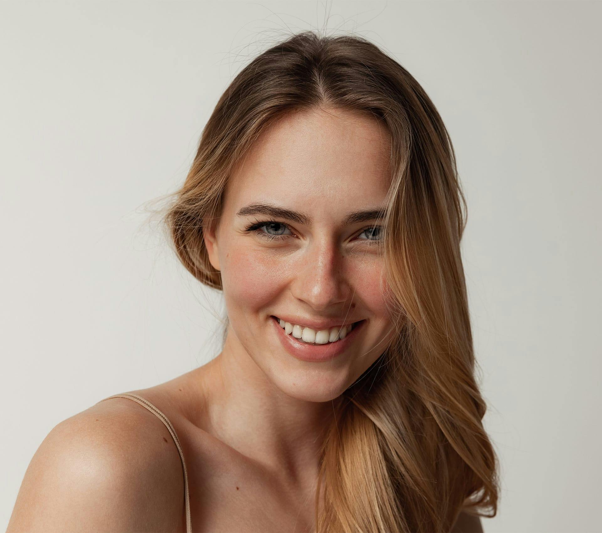 woman with hair on one side smiling forward