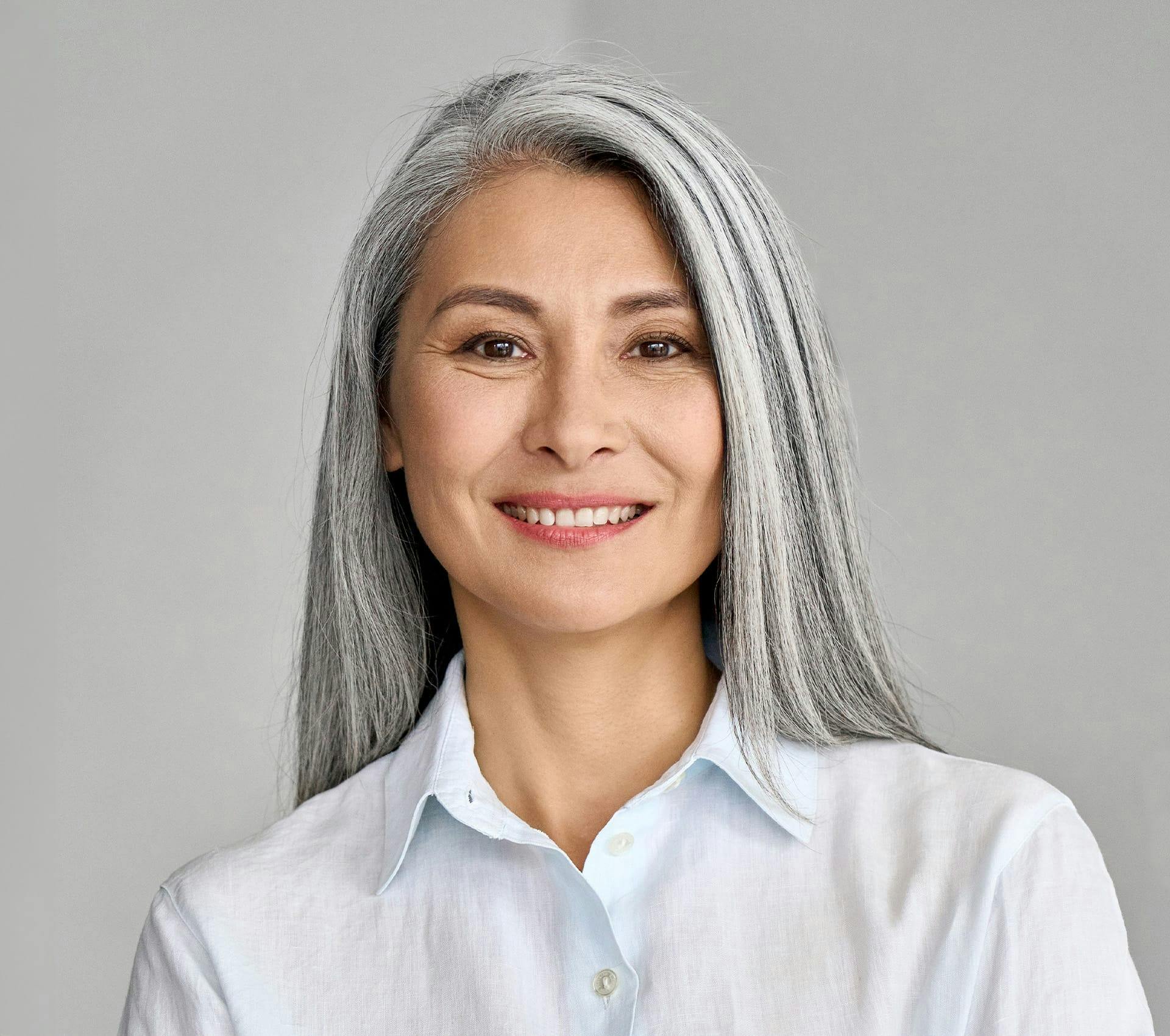 older woman in white polo smiling