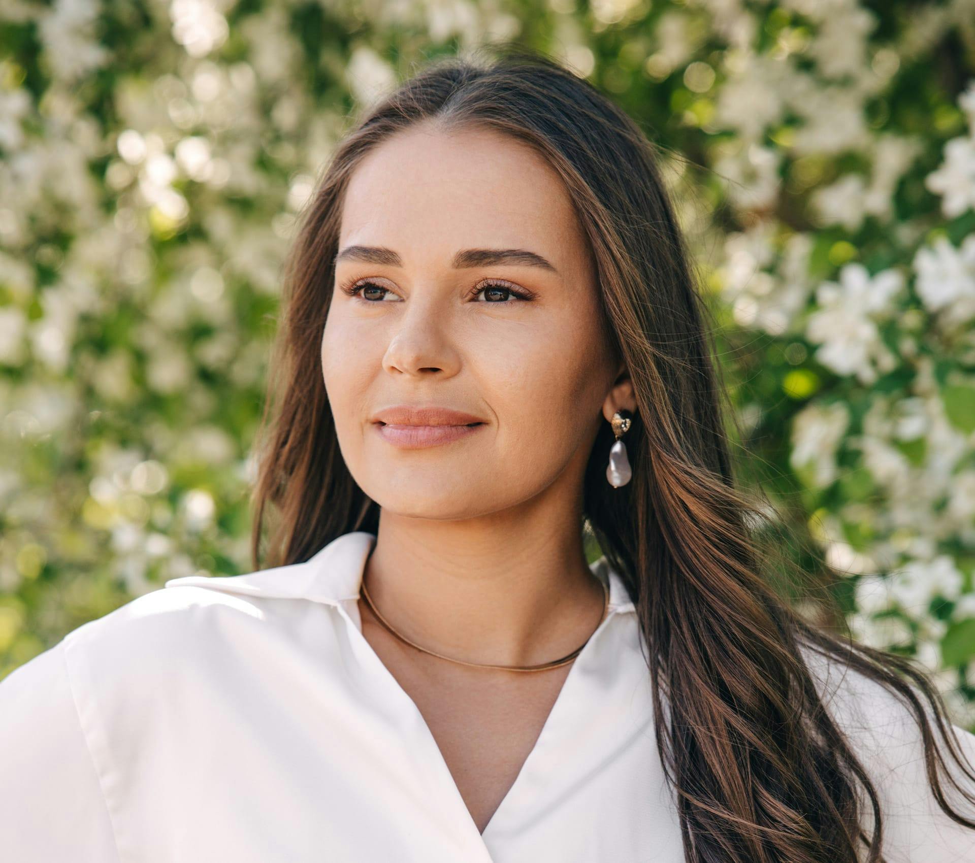 woman with brown hair in white top