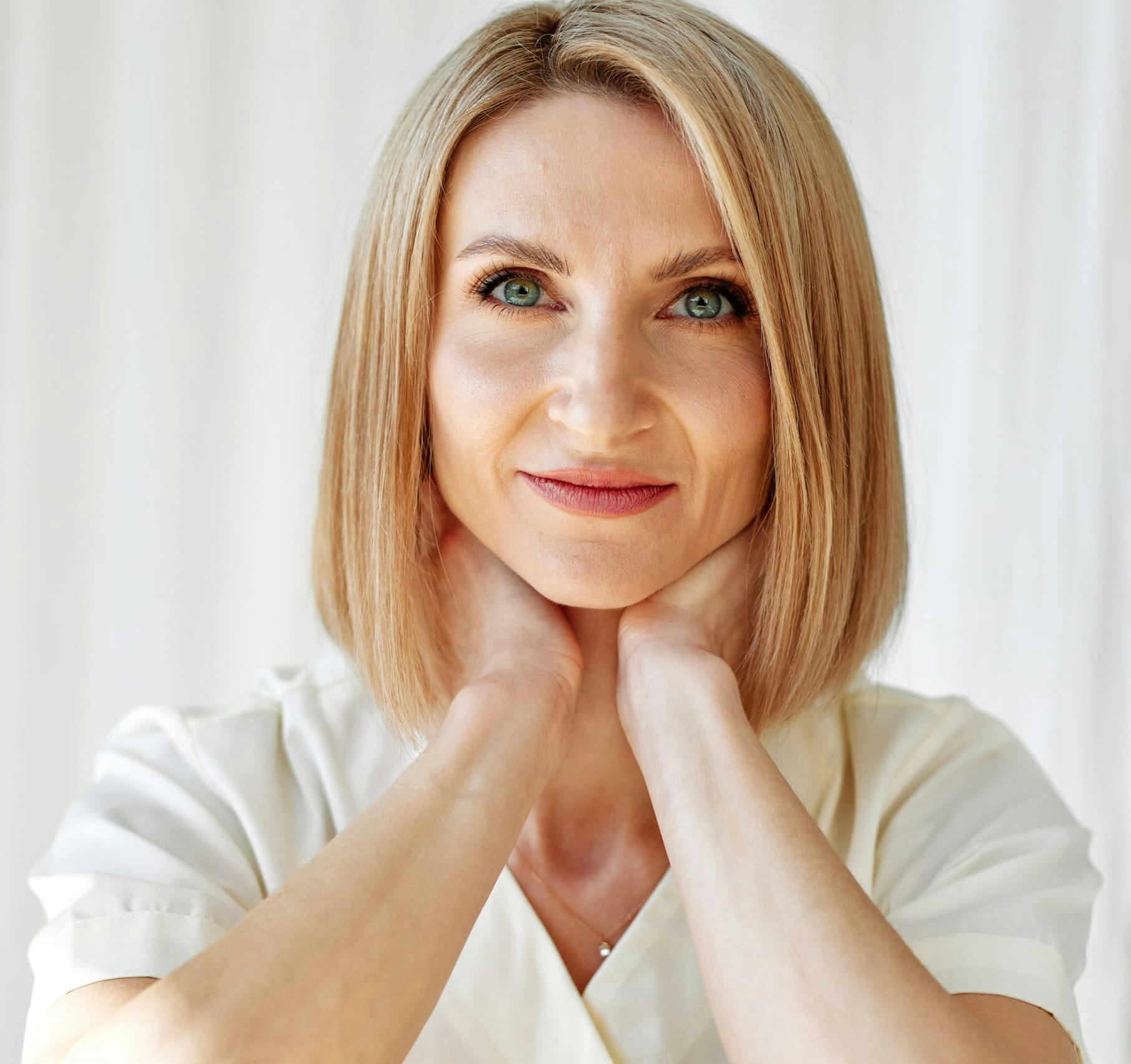 Woman with hands to her neck