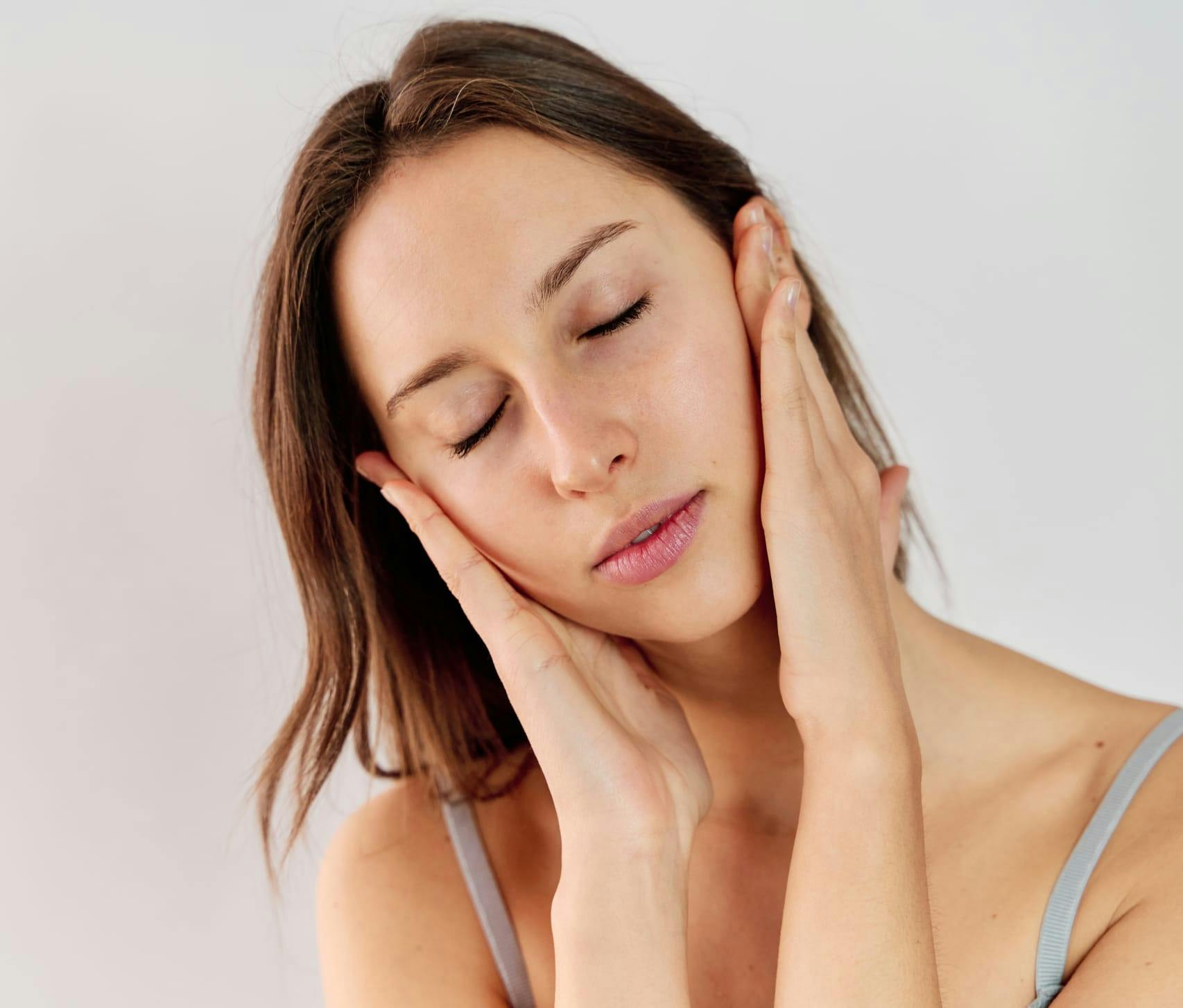 Woman with her hands to her cheeks, smiling