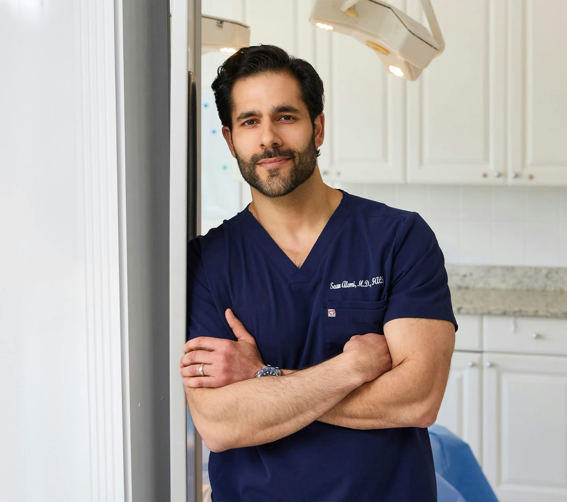 Dr. Alemi crossing his arms and leaning on door frame