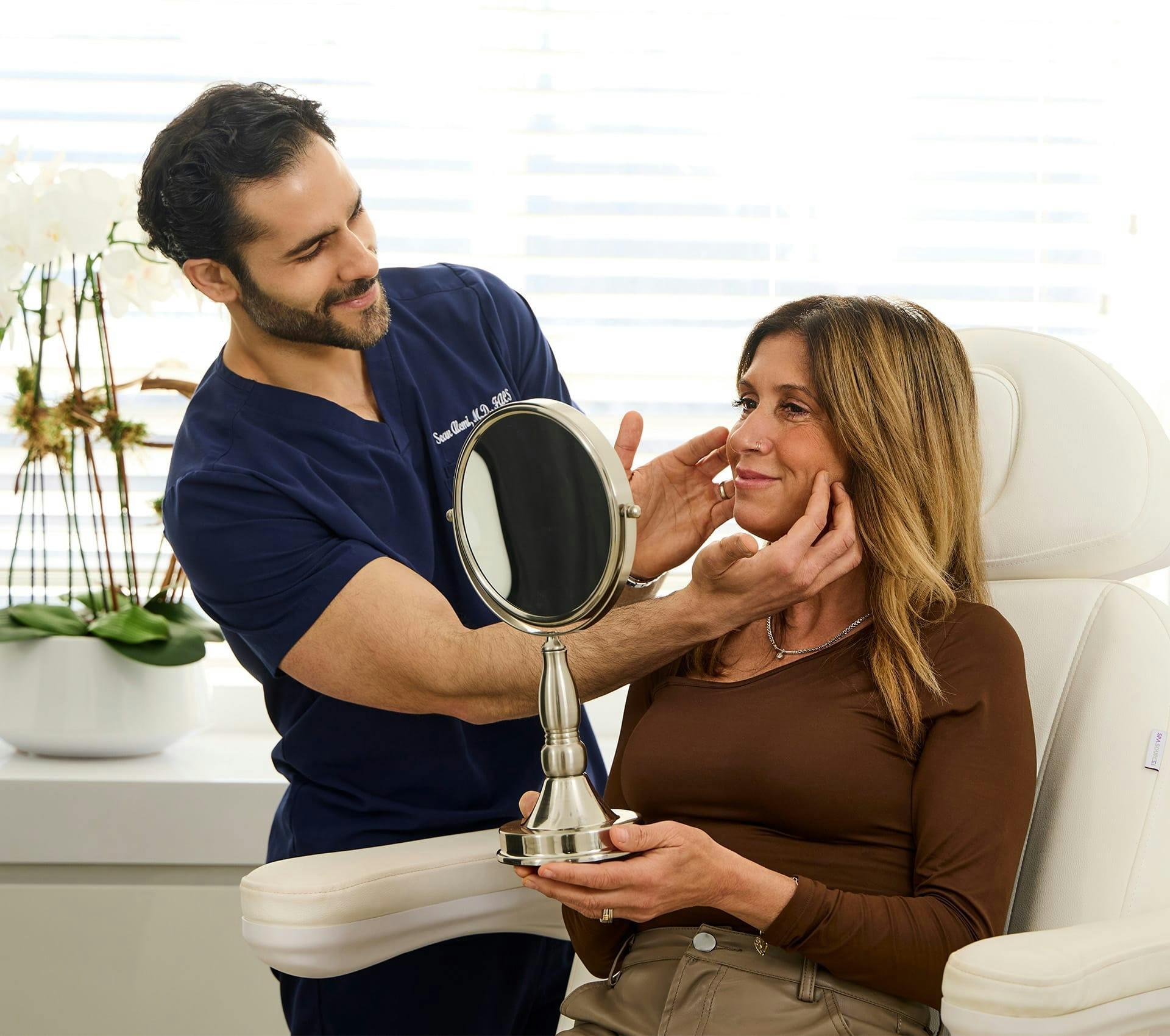 Dr. Alemi touching client's cheek's while she smiles