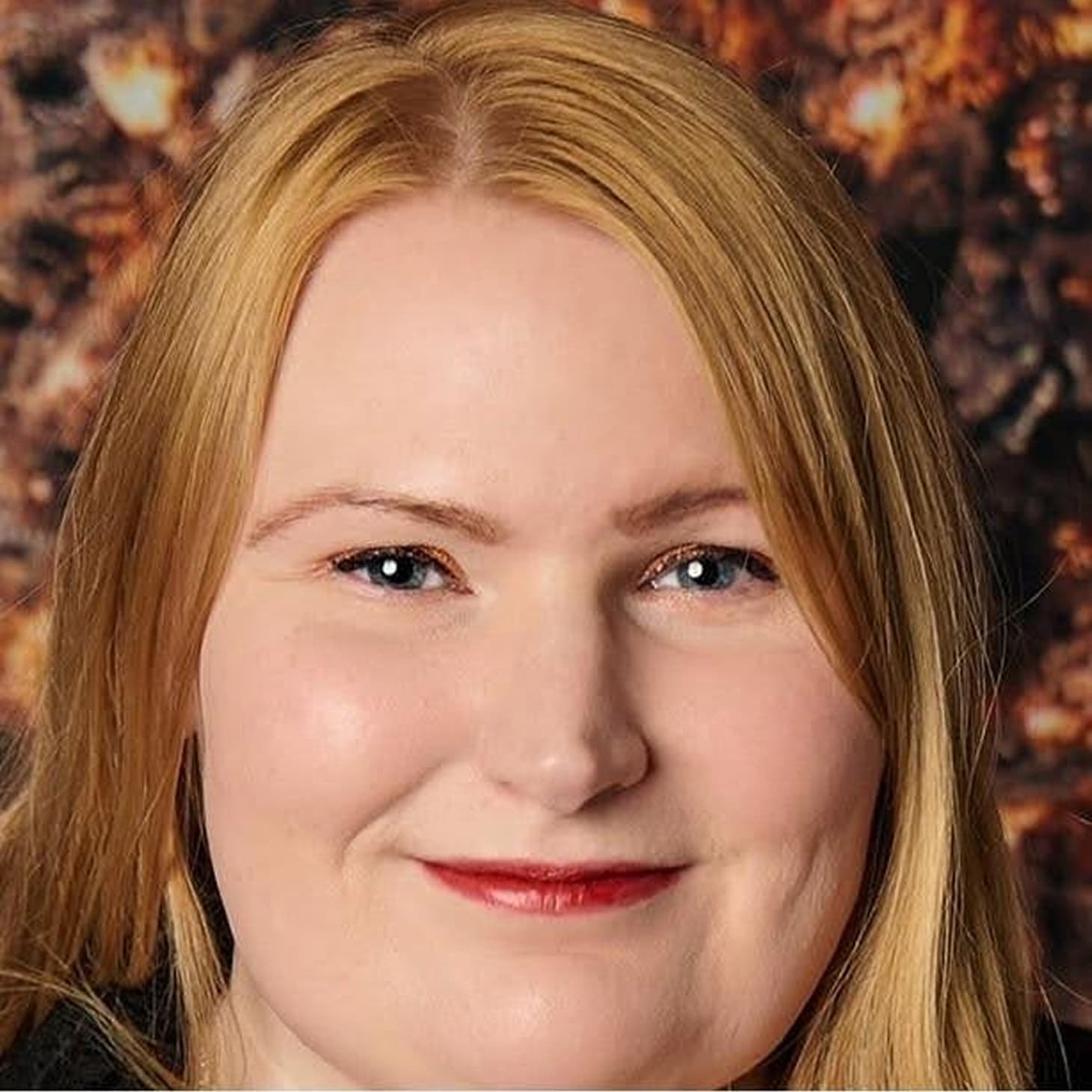 headshot of woman with blonde hair and wearing red lipstick