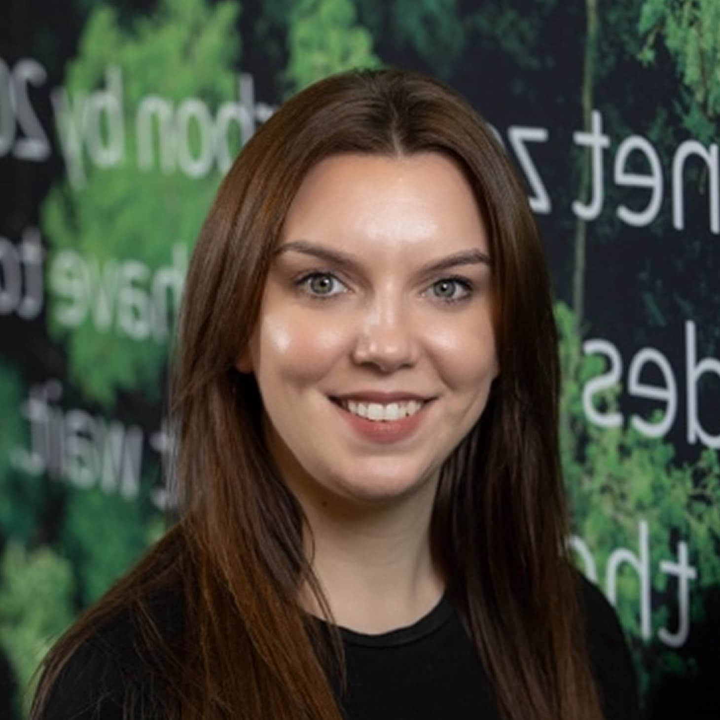 portrait shot of woman with long dark brown hair smiling