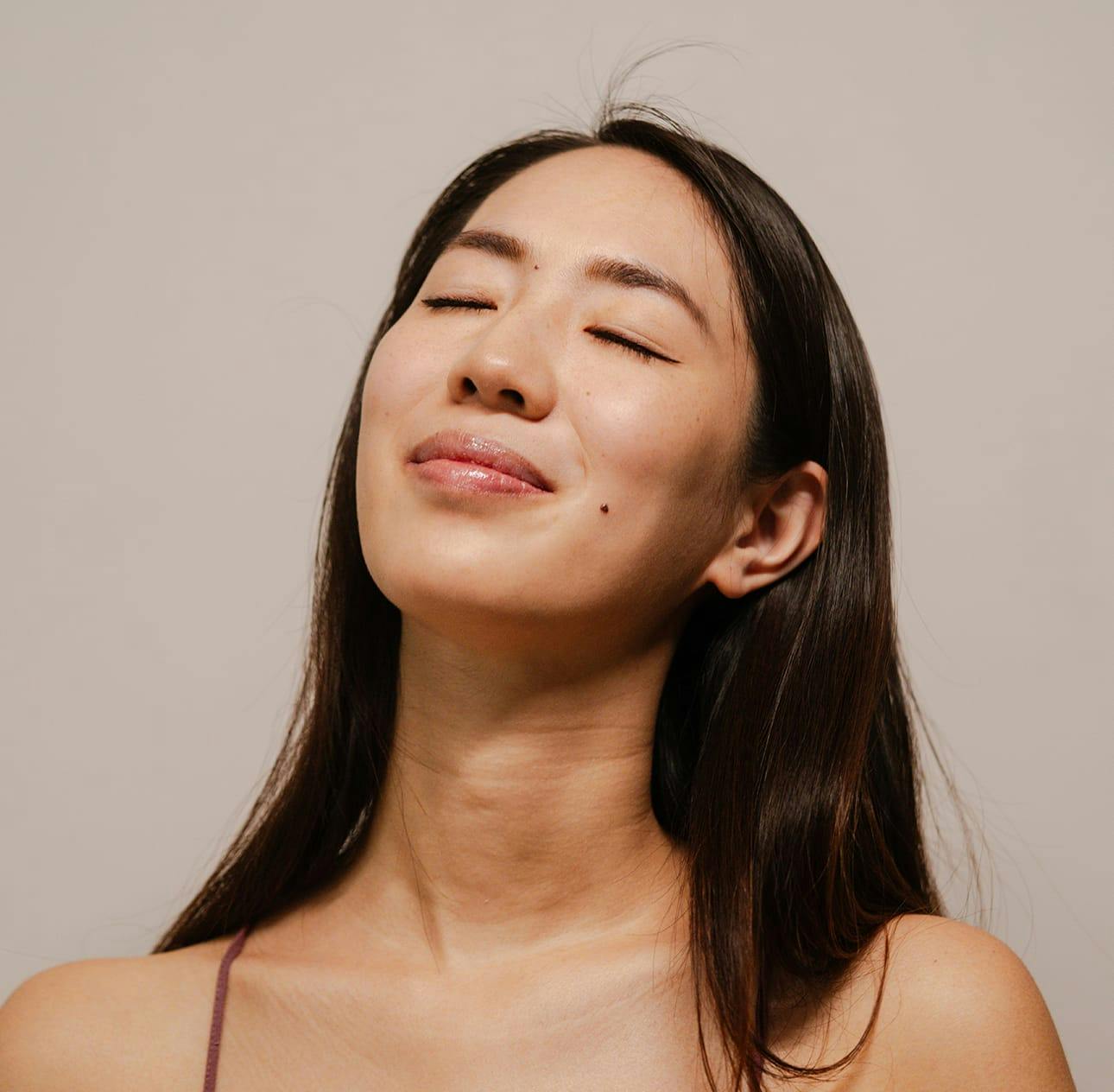 woman with her eyes closed tilting her head upwards