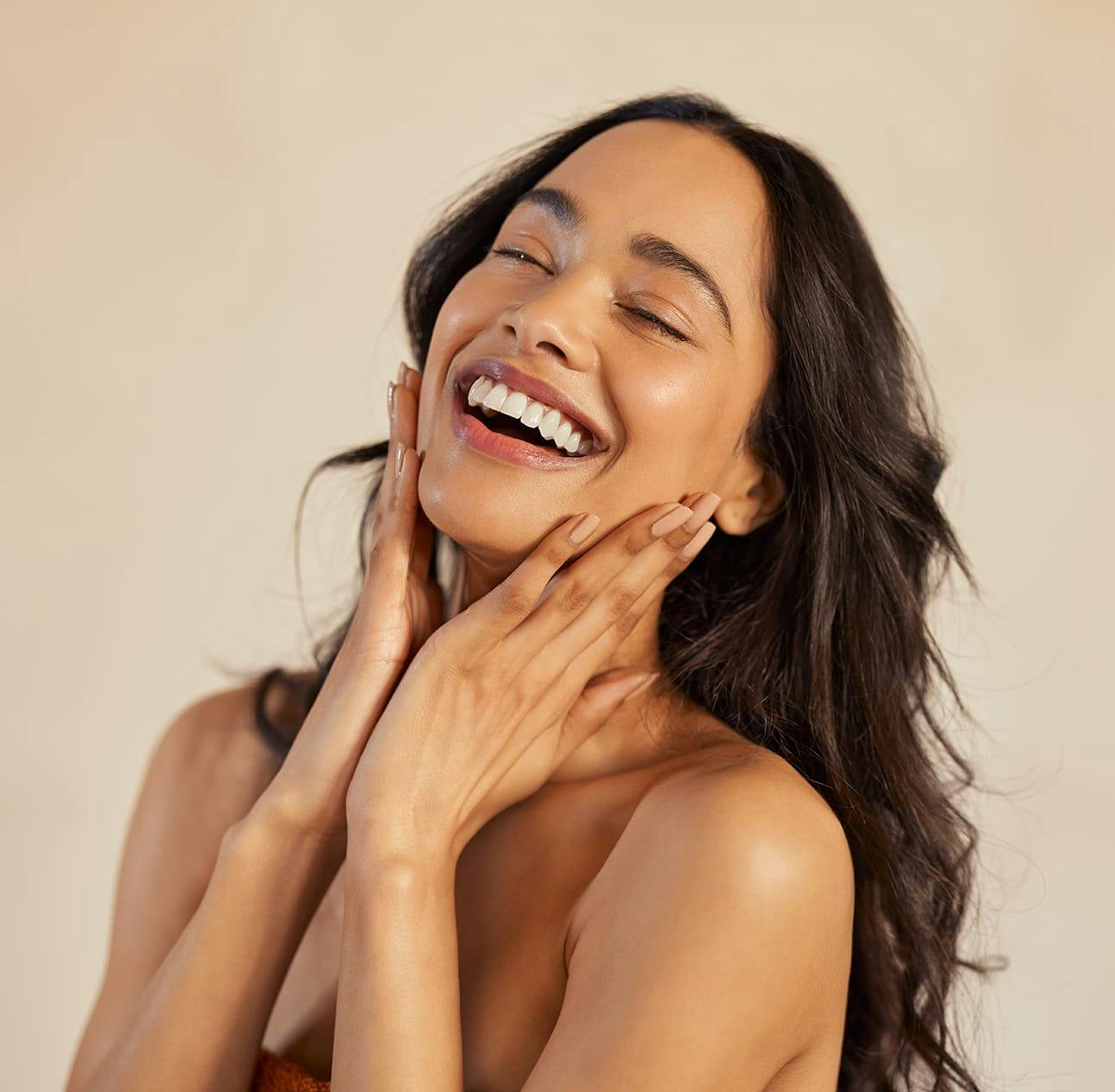 woman with long dark wavy hair smiling