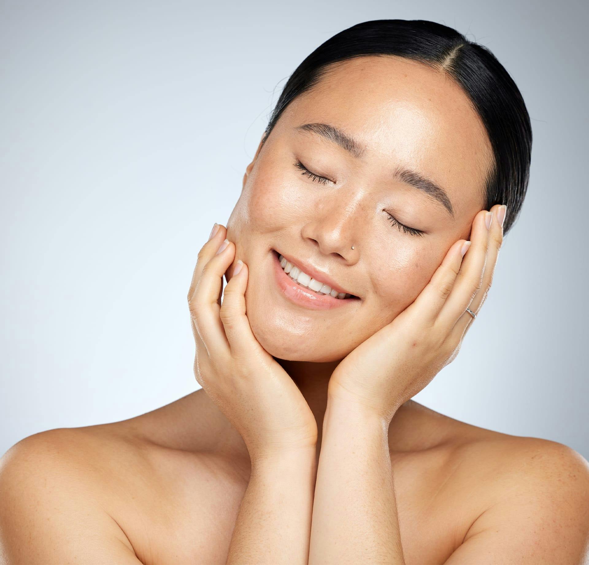 woman smiling and feeling her cheeks