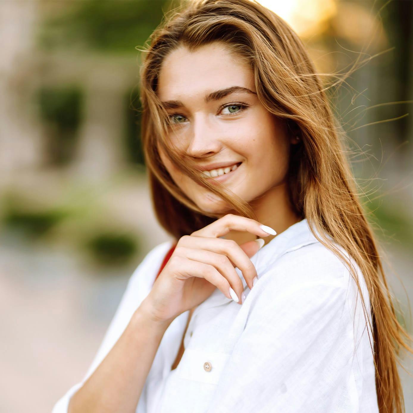 Photo of woman smiling in white shirt