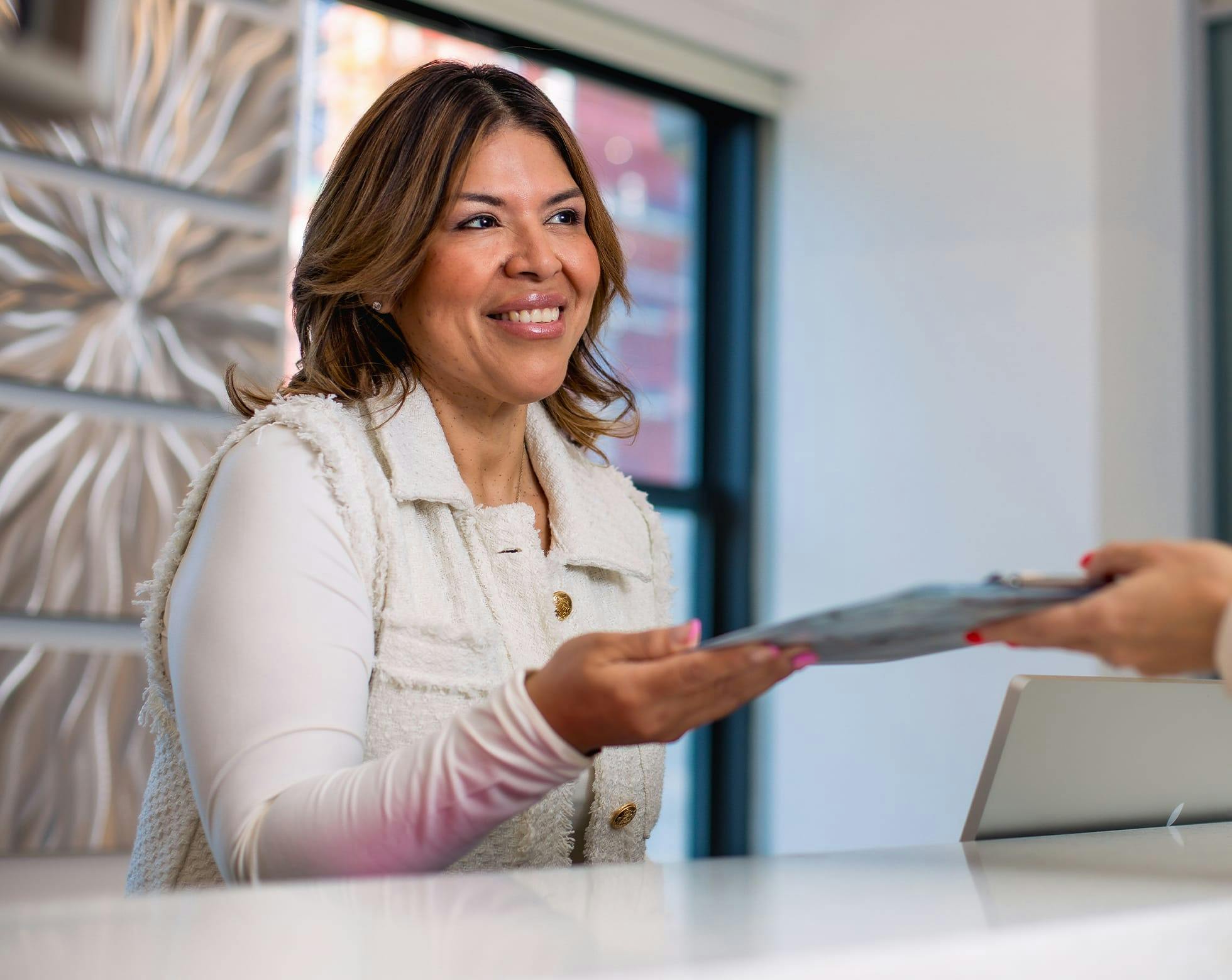 Woman smiling handing in forms