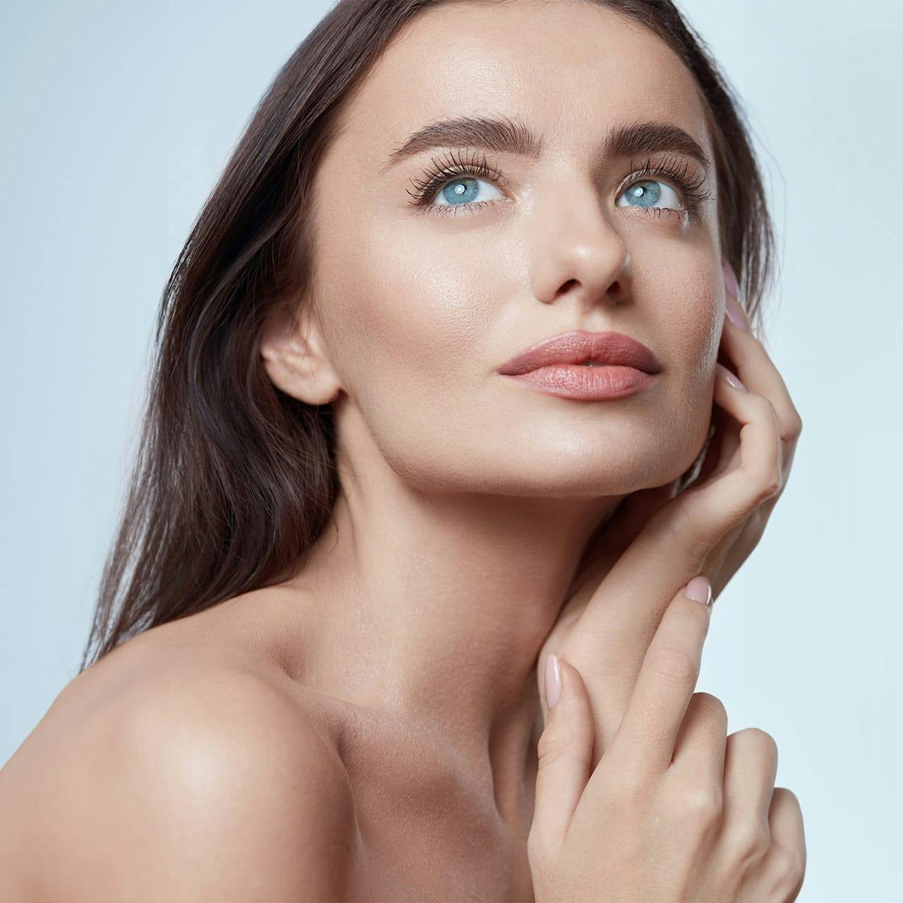 woman with hand on cheek looking up