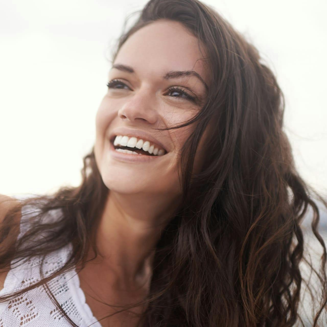 woman with wavy brown hair smiling