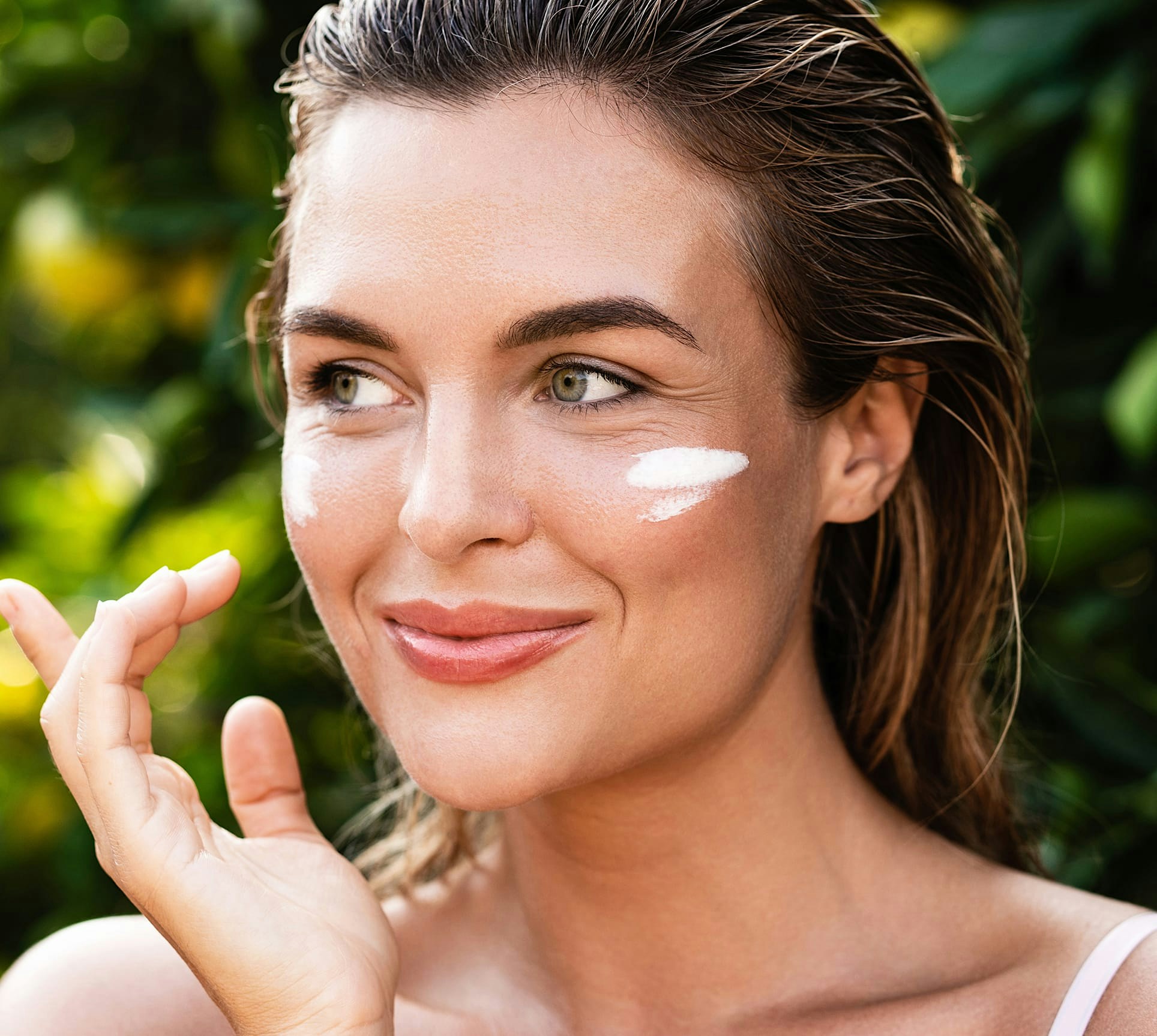 woman applying facial treatment