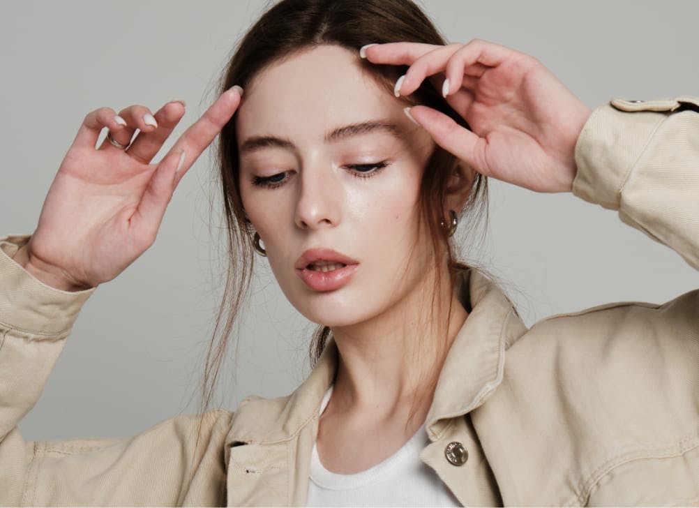 woman touching her the top of her face