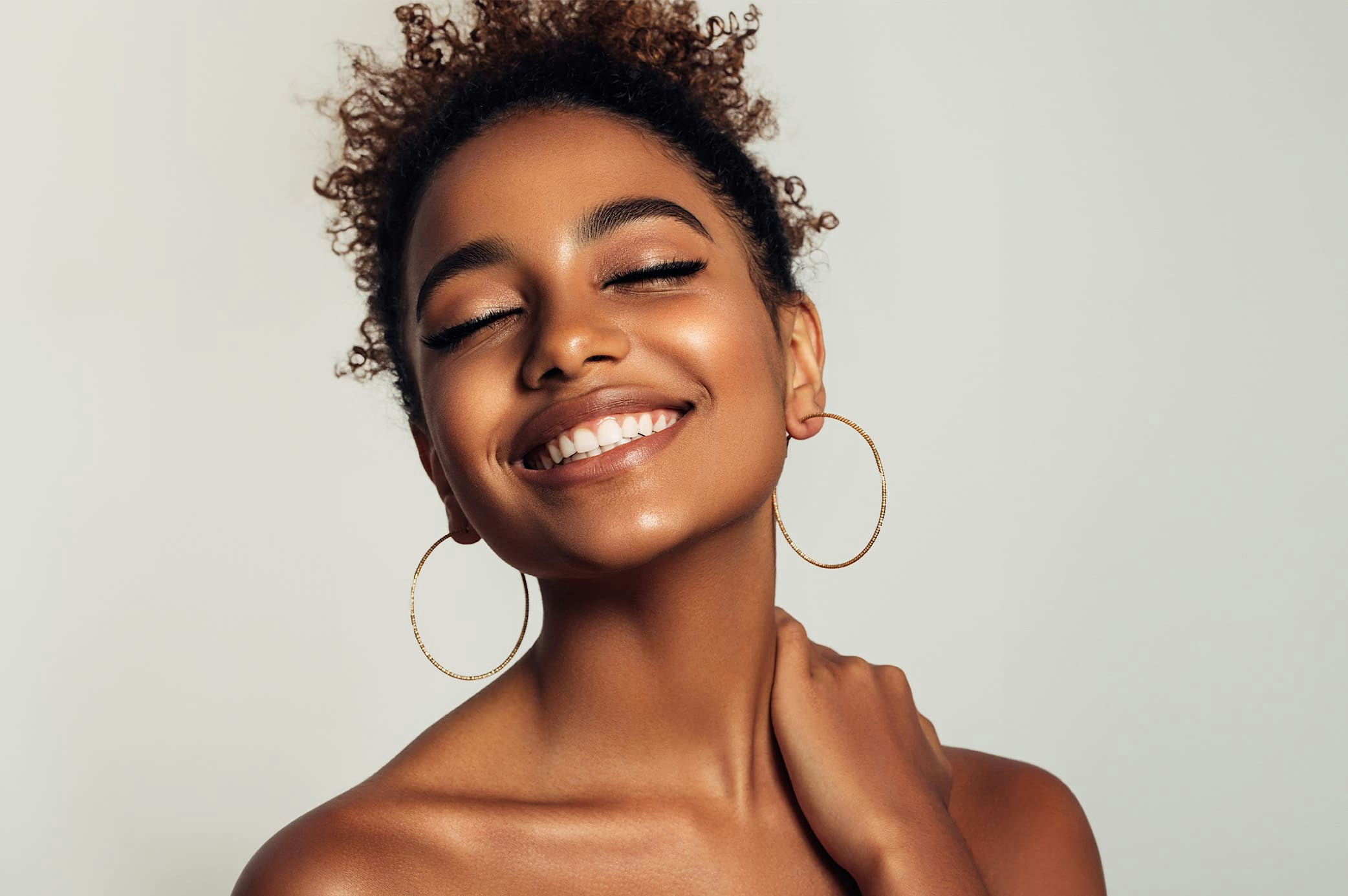 woman smiling grabbing her shoulder