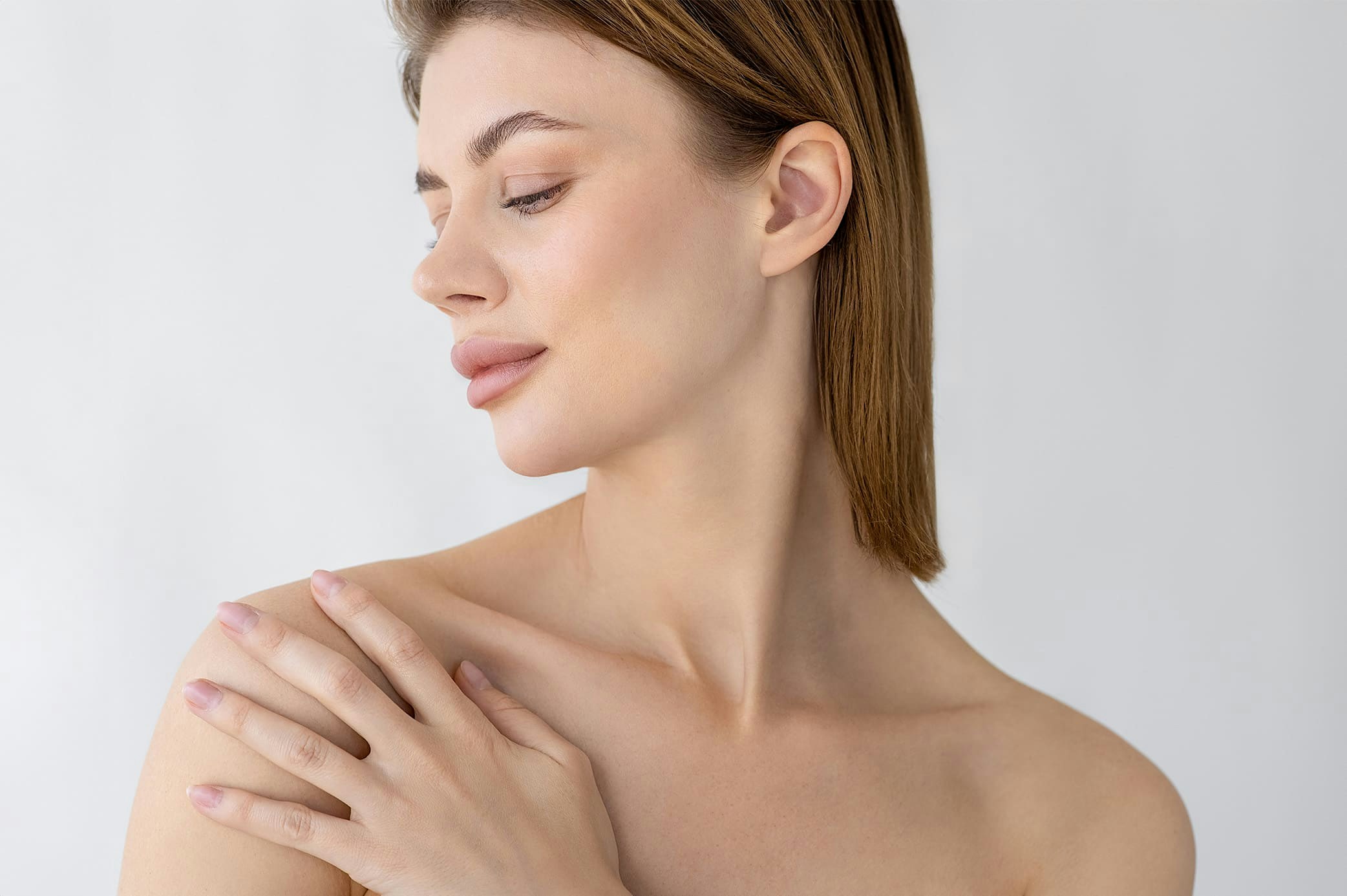 woman with short hair touching and looking at her shoulder