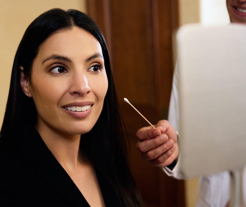 Woman smiling into hand mirror