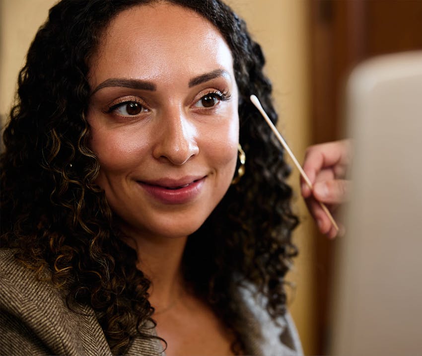 Woman looking in hand mirror