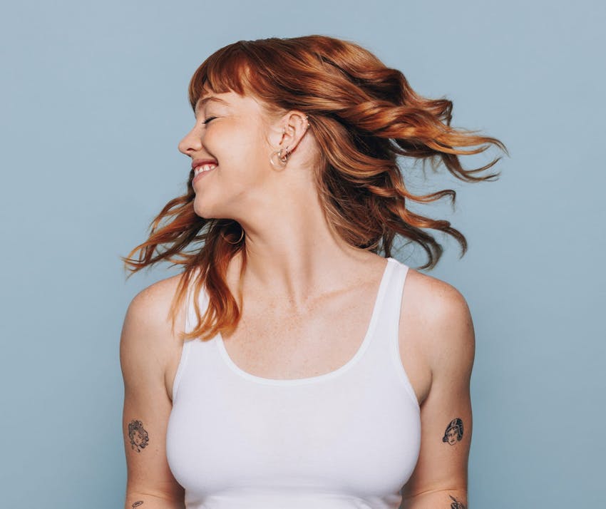 woman with red hair wearing a white tank top