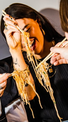 women eating noodles with chopsticks