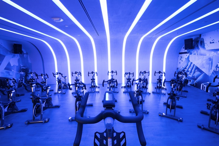 Cycling studio with stationary bikes and blue neon lighting