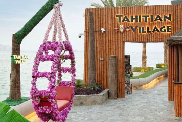 Entrance to Tahitian Village featuring a hanging flower swing and bamboo-themed decor