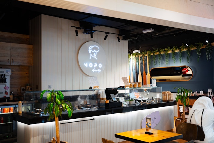 Cozy café with a modern counter, plants, and minimalist decor