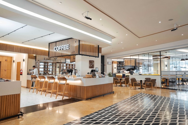 Modern coffee shop with a counter, seating area, and a stylish floor design