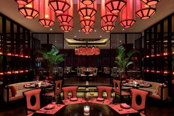 Elegant dining area with red lighting and modern decor.