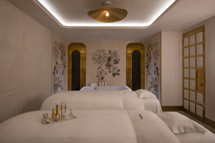 Serene spa treatment room with massage tables and soft lighting.
