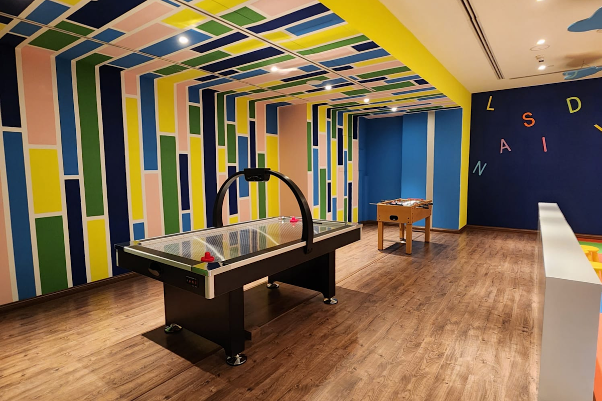 Colorful game room with air hockey and foosball tables.
