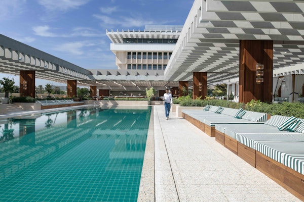 Outdoor swimming pool area with lounge chairs and modern architecture.